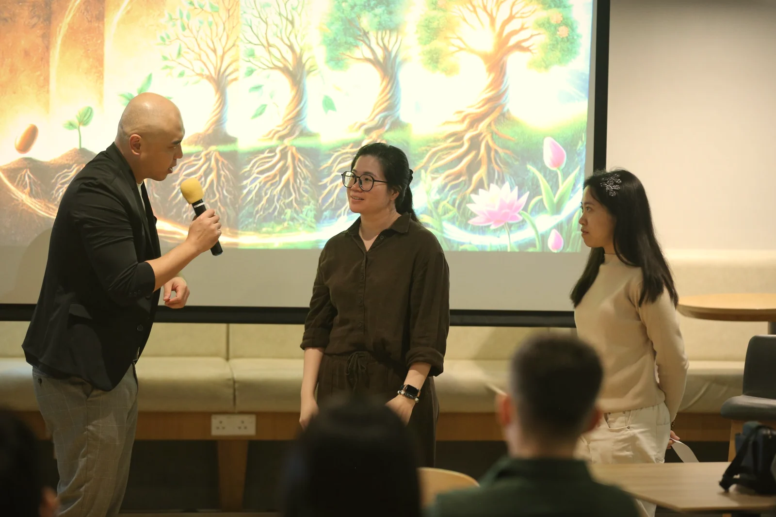Zhi-Harn with workshop participants in front of a seed-to-tree illustration